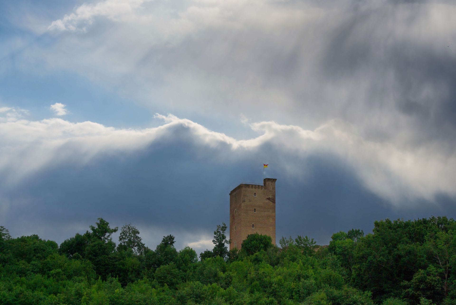 Le donjon de Montaner émergeant de la crête des arbres