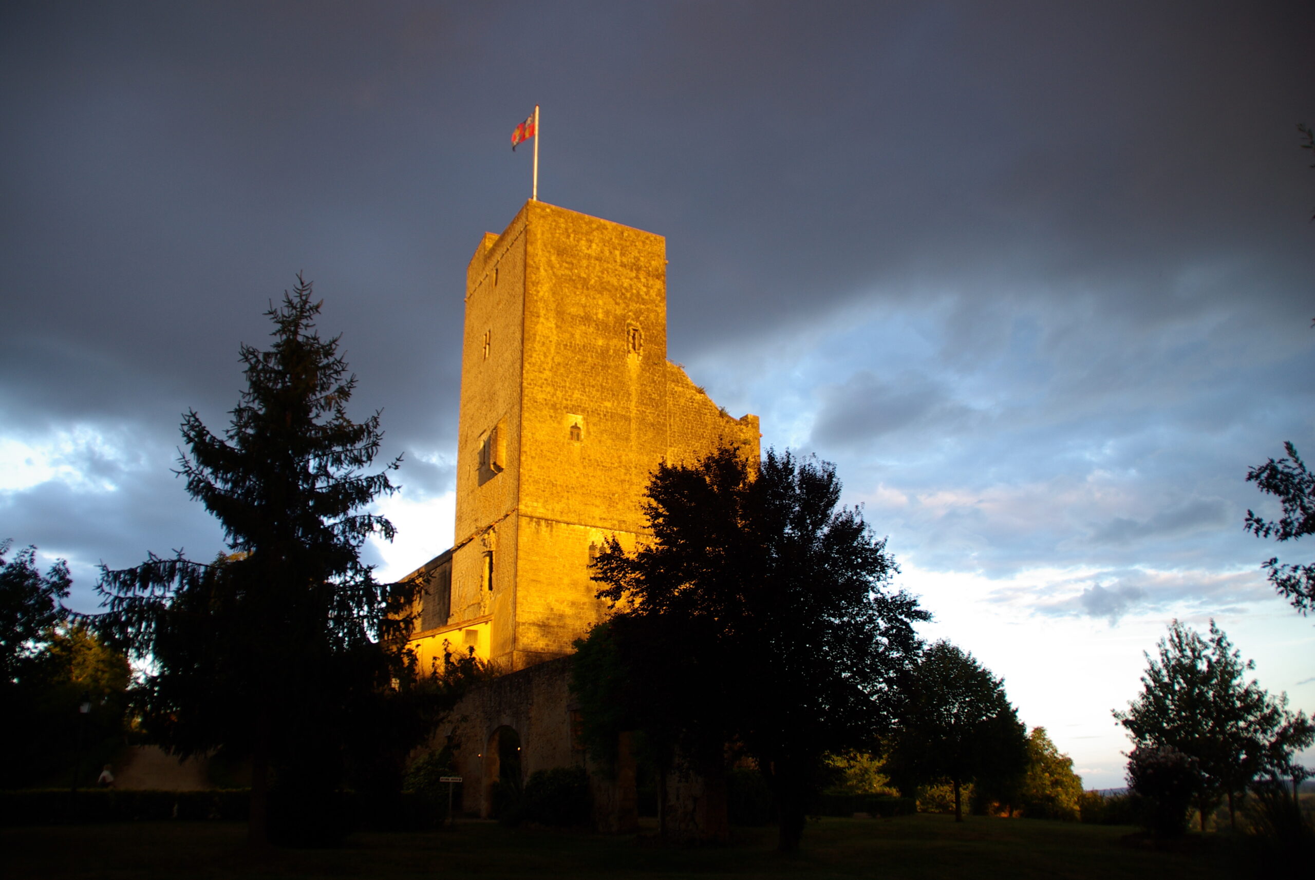 La tour de Termes-d’Armagnac dans une lumière chaude sous un ciel bleu sombre