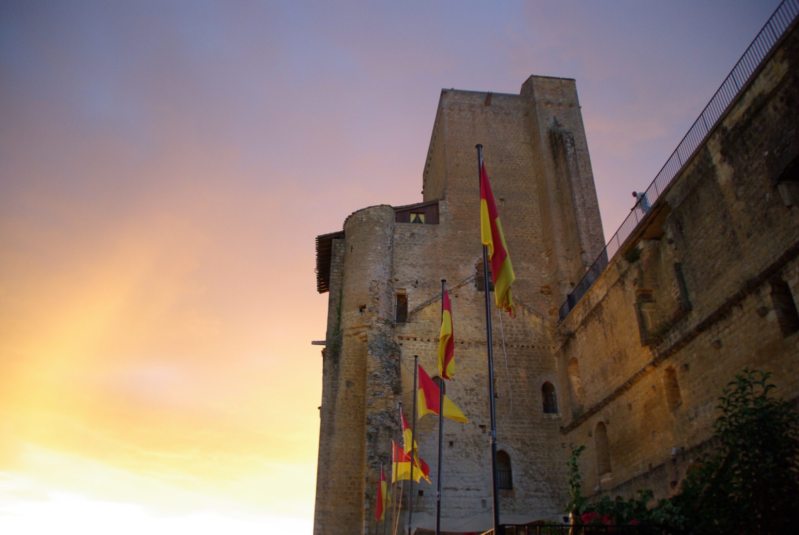 La tour de Termes-d’Armagnac illuminée d’or sous un ciel bleu sombre