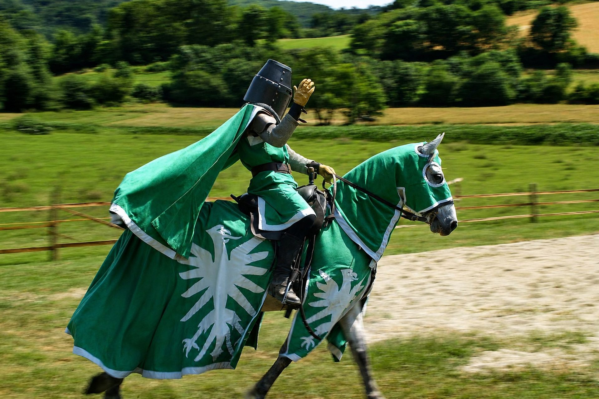 Chevalier vert au galop, cape déployée et main levée