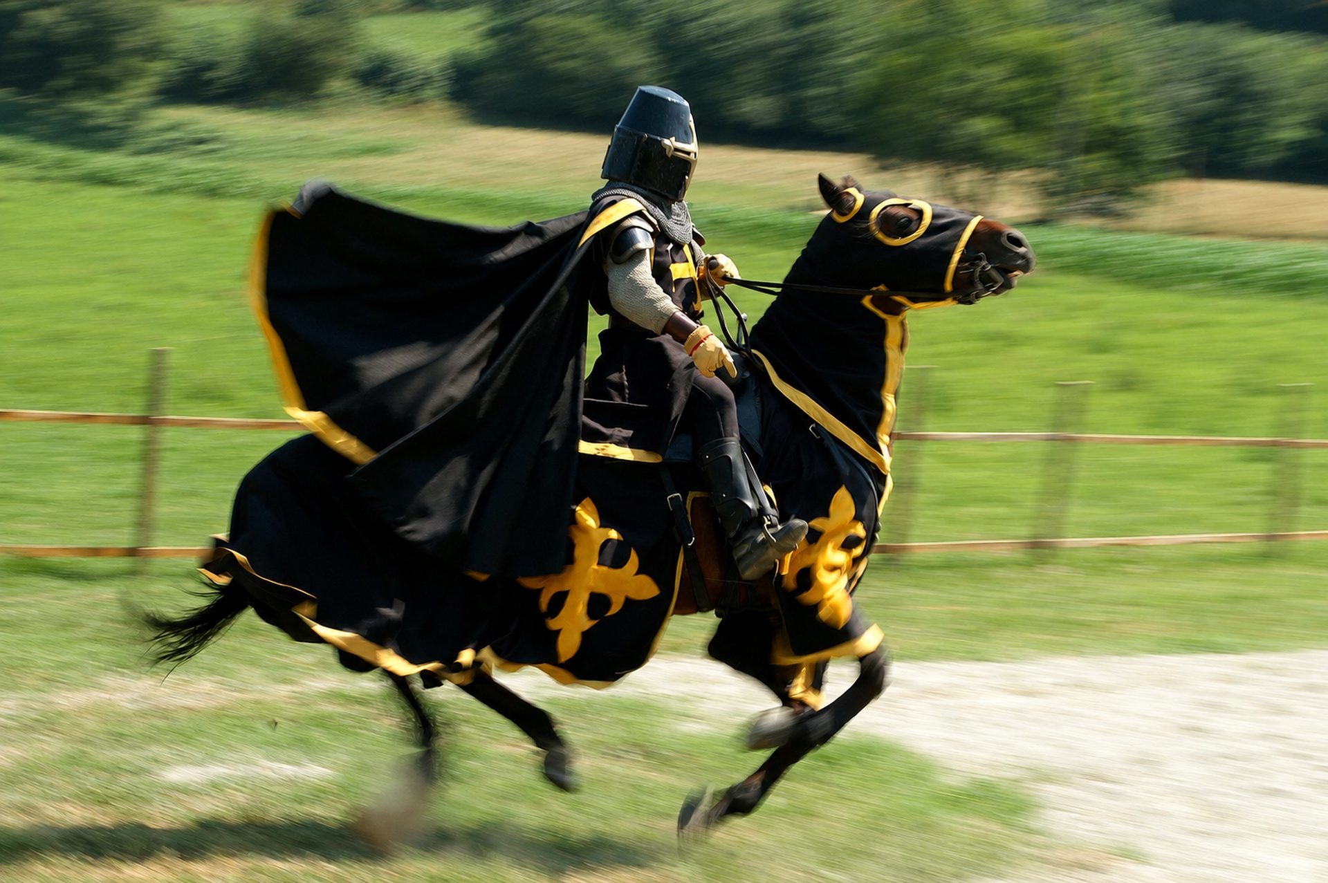 Chevalier noir et or emporté au galop dans un filé d'arrière-plan