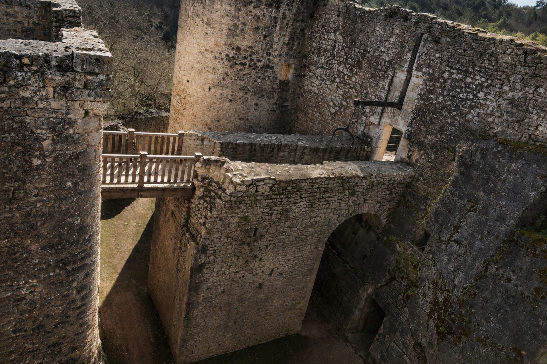Vue plongeante sur un pont, un fossé et une arche défensive