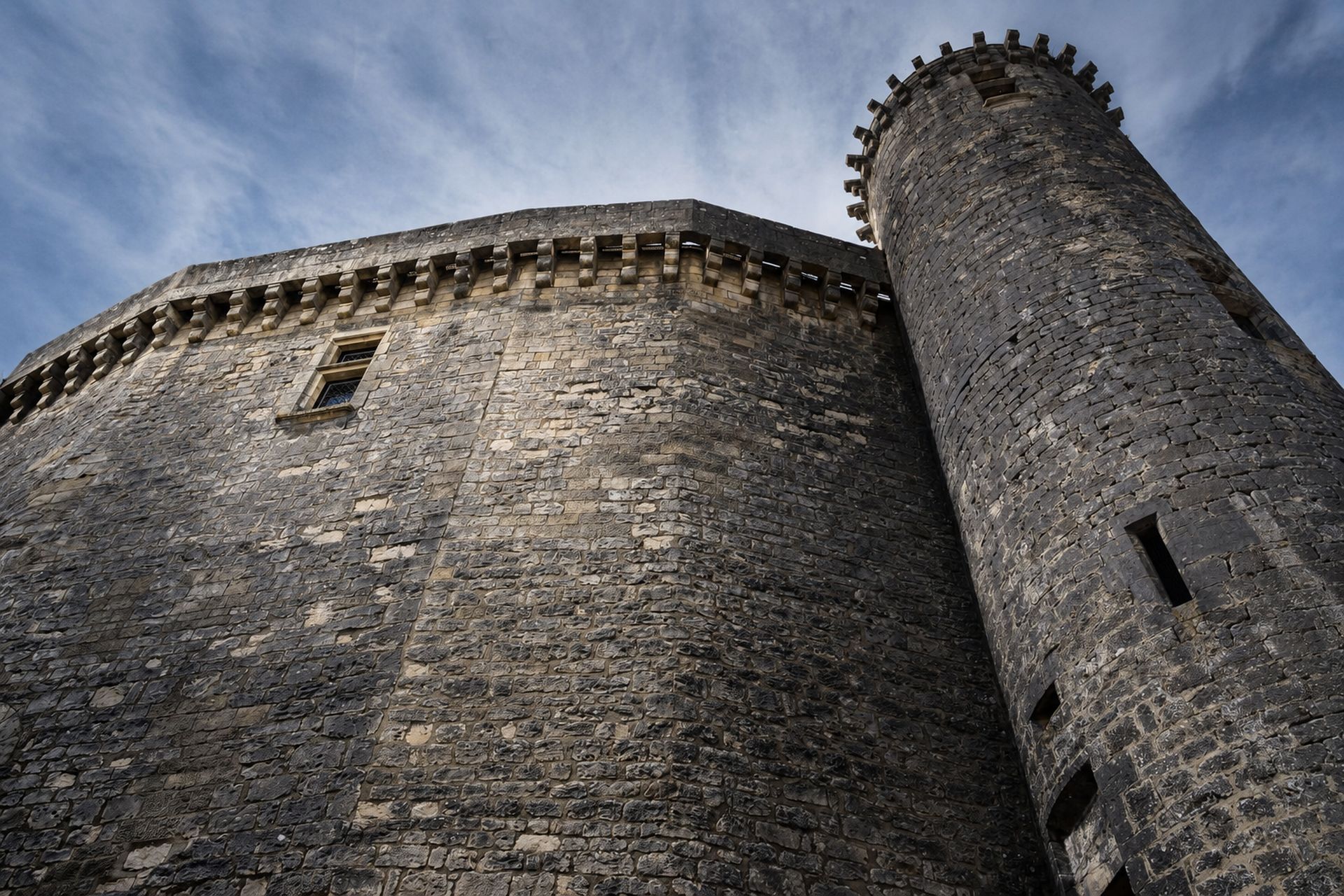 Contre-plongée sur une haute muraille courbe et sa tour