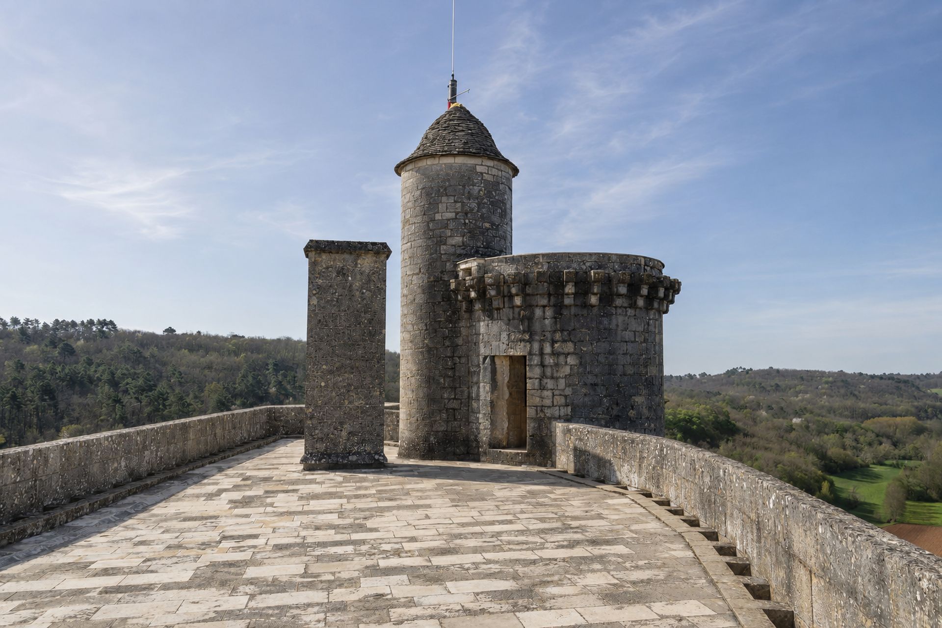 Terrasse dallée conduisant vers une tour au-dessus de la vallée