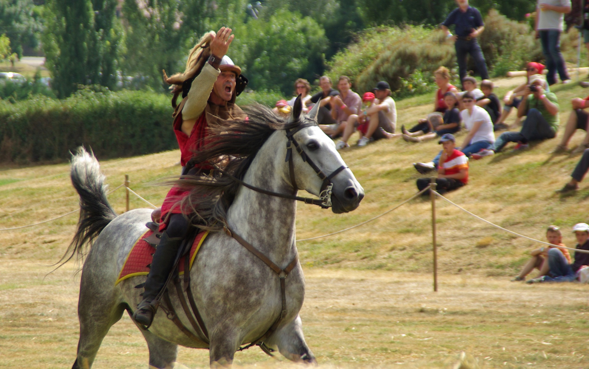 Un cavalier salue la foule dans l’élan de sa monture.