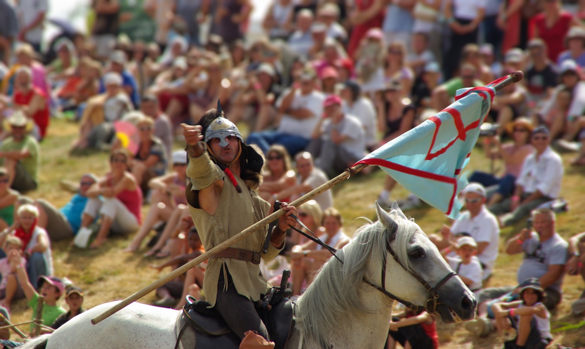 Enseigne au vent, le cavalier fend l’arène devant le public.