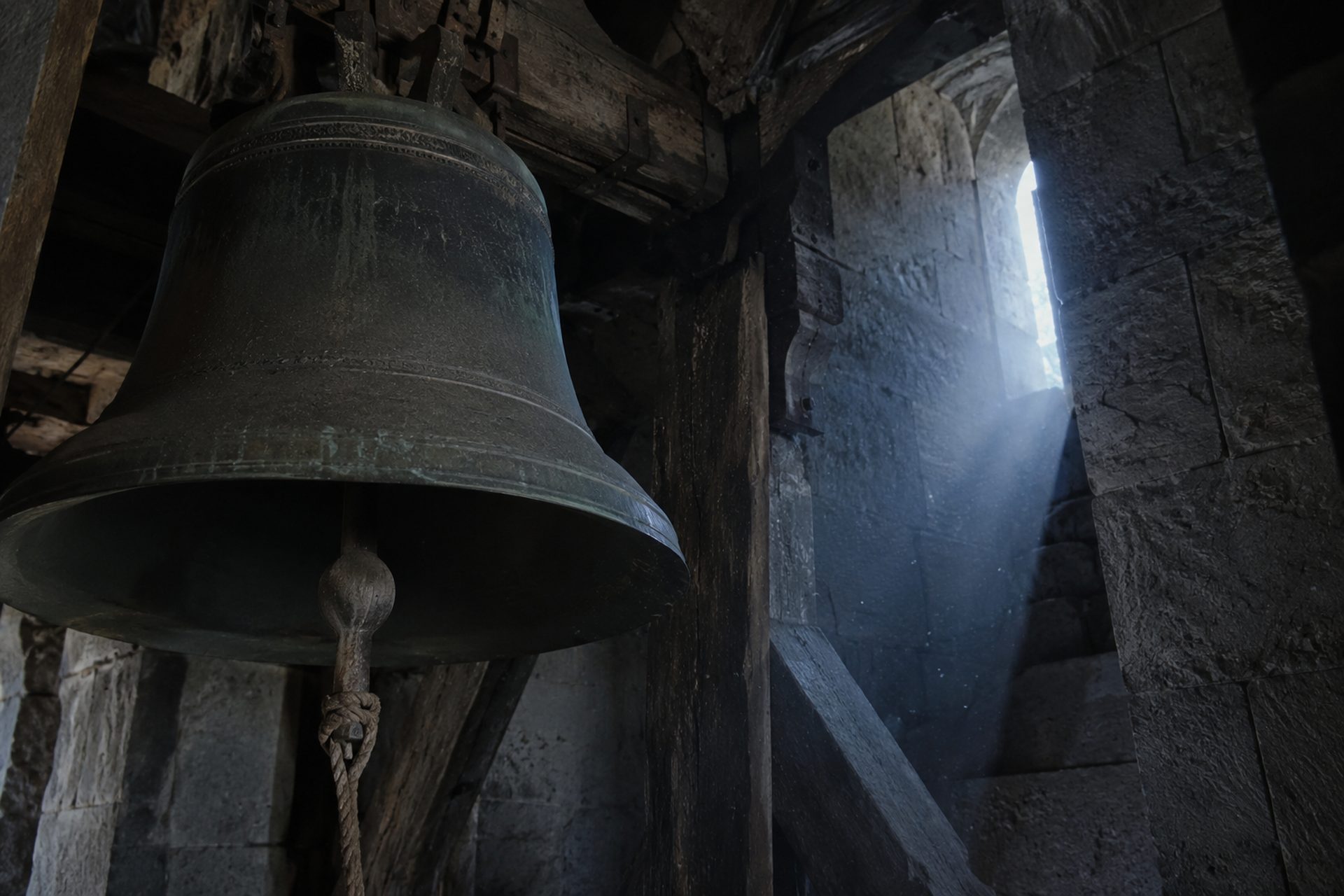 Vieille cloche de bronze dans un clocher de pierre, évoquant le tocsin de la Grande Peur