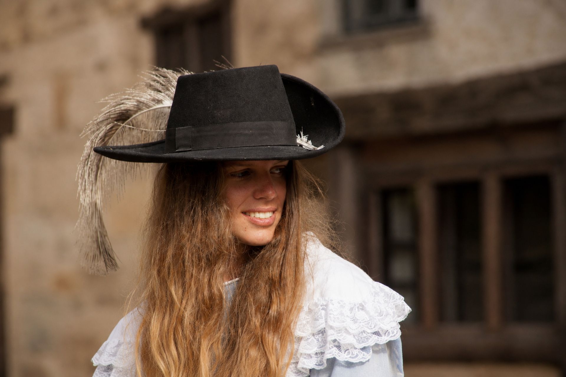 Jeune femme en costume portant un chapeau à plume claire
