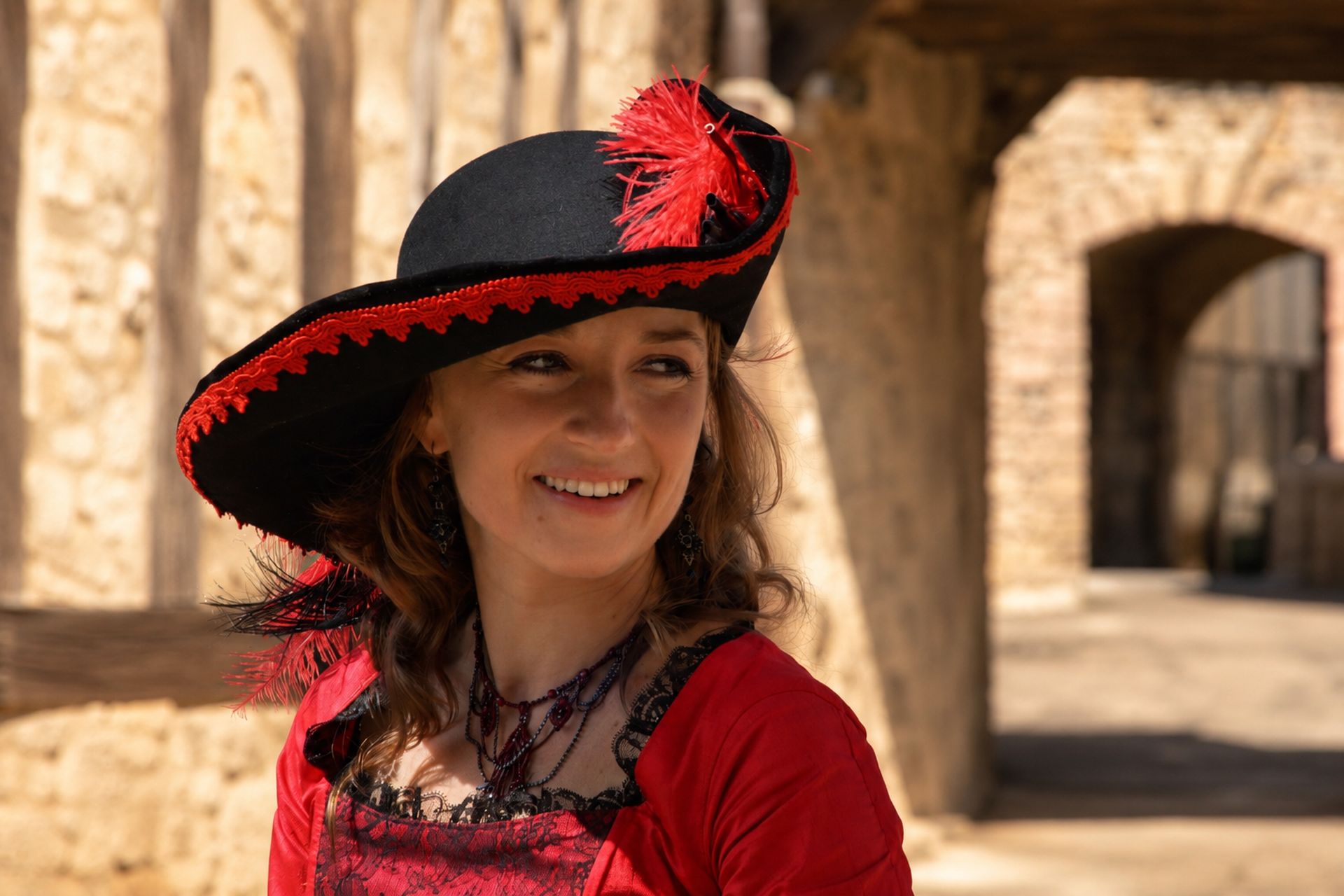Dame souriante au grand chapeau noir et rouge