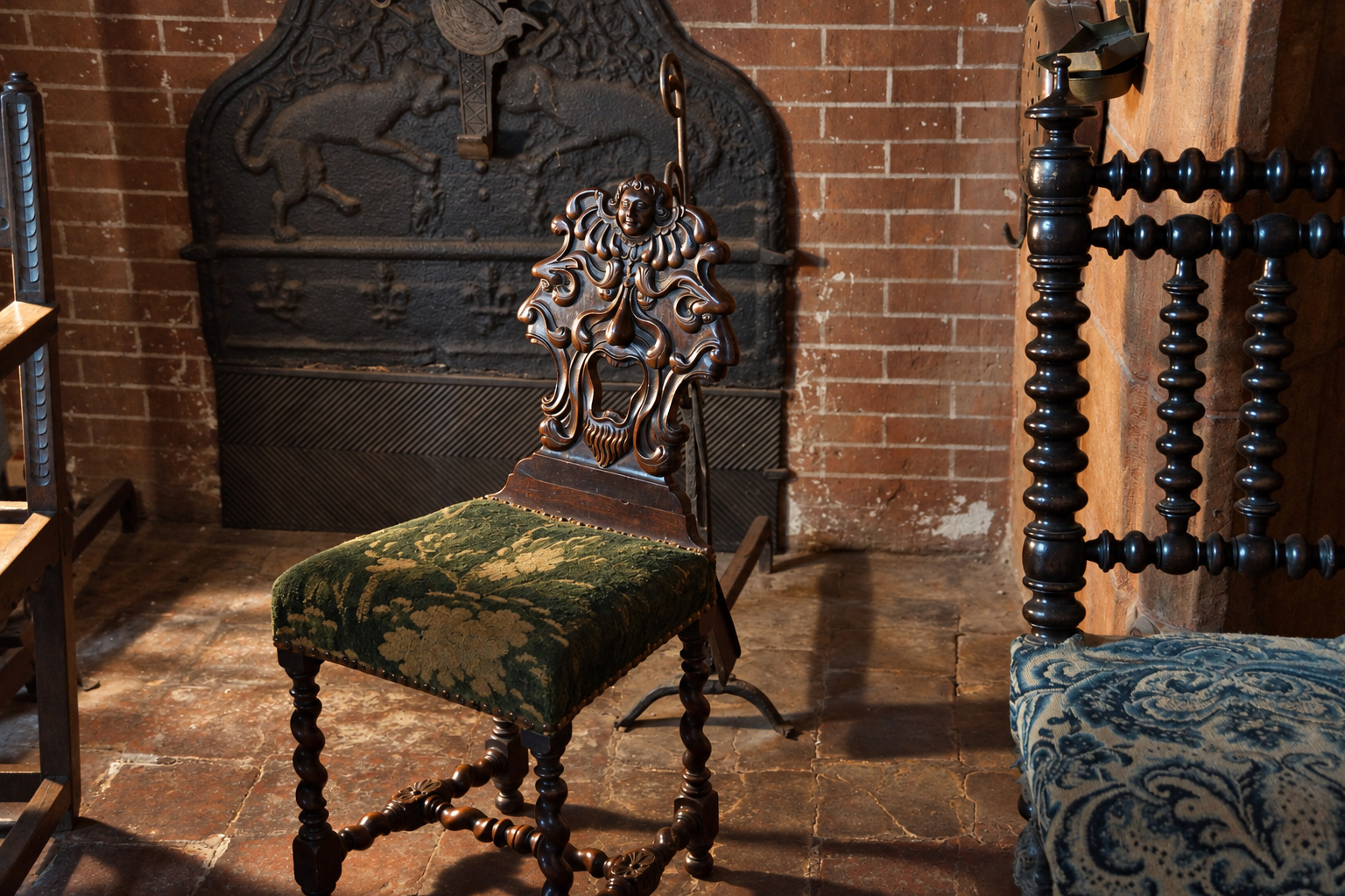 Chaise sculptée placée devant une cheminée ancienne
